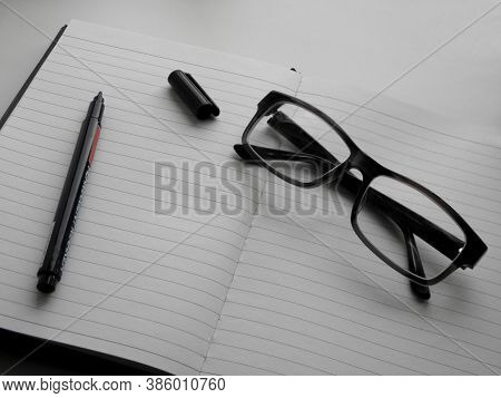 School Notebook With Glasses And Marker On The Table