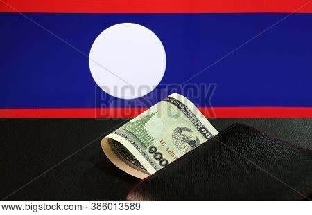 One Thousand Of Banknote Currency Lao Kip With Black Wallet On The Black Floor With Laos Nation Flag