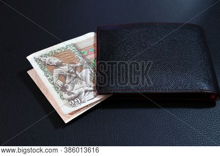 Seventy Five Of Banknote Currency Myanmar Kyats With Black Wallet On The Black Floor. It Is The Retr