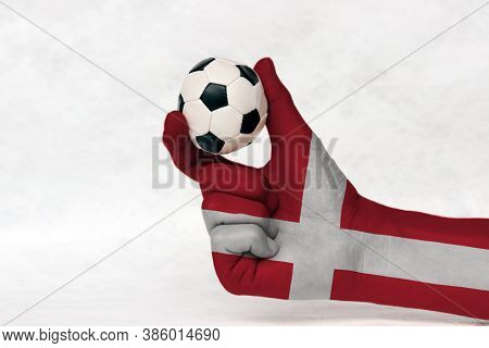 Mini Ball Of Football In Denmark Flag Painted Hand, Hold It With Two Finger On White Background. Con