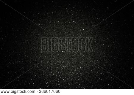 Black Texture With Micro-relief And Glitter. Black Glitter Texture With Illuminated Center