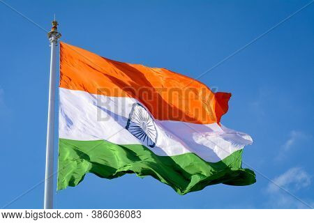 Indian Flag Waving In A Air On Independence Day Of India. With Natural Blue Sky And Cloud Background