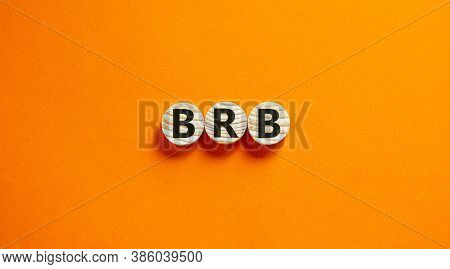 Wide View Image Of Brb Abbreviation Spelled On Wooden Circles. Placed Over Beautiful Orange Backgrou