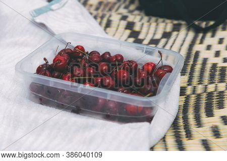Ripe Sweet Cherries In A Boxing Box On A Bedspread On The Beach. Cherry Season In Early Summer. Ripe