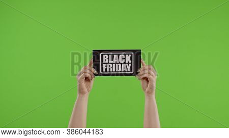 Black Friday Advertisement Inscription On Paper Sheet In Womans Hands On Green Screen. Holiday Disco