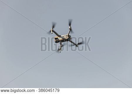 Grey Drone With Digital Camera. Drone Hovering In Blue Sky. Radio Control Helicopter. Closeup Drone 