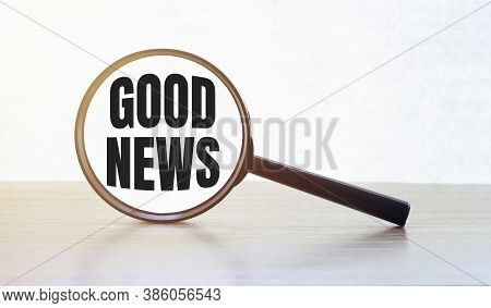Magnifying Glass With Text Good News On Wooden Table