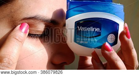 District Katni, India - December 30, 2019: An Indian Girl Applying Vaseline Moisturizing Cream On Ey