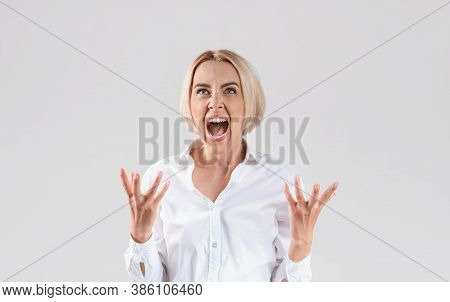 Beautiful Blonde Businesswoman In Office Wear Shouting In Anger On Light Studio Background. Female C