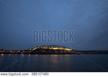 Petrovaradin Fortress In Novi Sad, Serbia, On Danube River, On A Cloudy Autumn Night Evening. It Is 