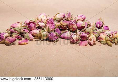 A Bunch Of Tea From Dried Buds And Petals Of A Lilac Damask Rose Lies On A Paper Background