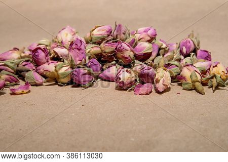 A Bunch Of Tea From Dried Buds And Petals Of A Lilac Damask Rose Lies On A Paper Background