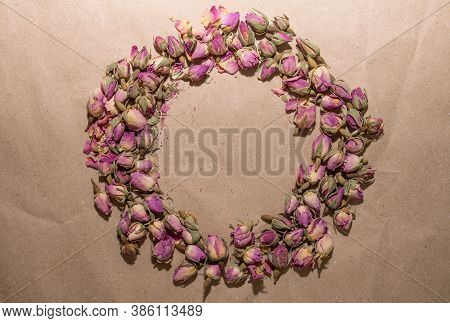 Tea Made From Dried Buds And Petals Of A Purple Damask Rose Lies In The Form Of A Wreath On A Paper