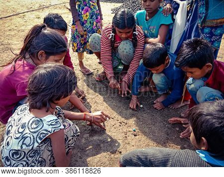 District Katni, India - January 01, 2020: Asian Poor Village Children Playing Goli Game Together At 