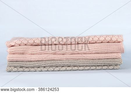 Pile Of Pink Knitted Cashmere Scarves, Sweaters On Light Blue Background. Folded Autumn And Winter C
