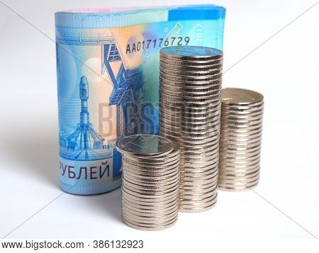 A Rolled Up Bundle Of Russian Banknotes Of 2000 Rubles Stands On A White Paper Background. In Front 