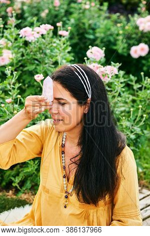 Woman Healer Holding Natural Mineral Kunzite Next To Head