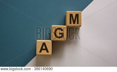 Wood Cubes With Acronym 'agm' - 'annual General Meeting' On A Beautiful White And Blue Background. B