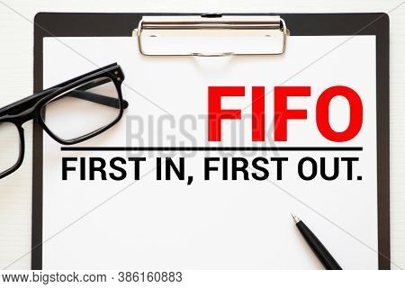 On The Table Lies A Smartphone, A Calculator And A Notebook With The Inscription- Fifo. First In, Fi
