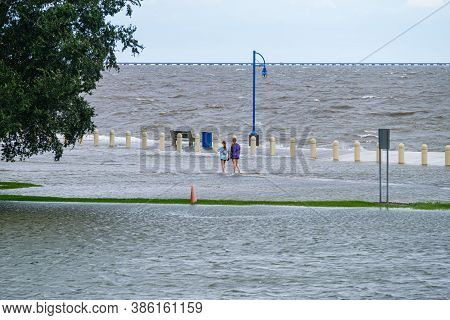 New Orleans, Louisiana/usa - 9/15/2020: Two Girls Wading In Flooded Street Along Lake Pontchartrain