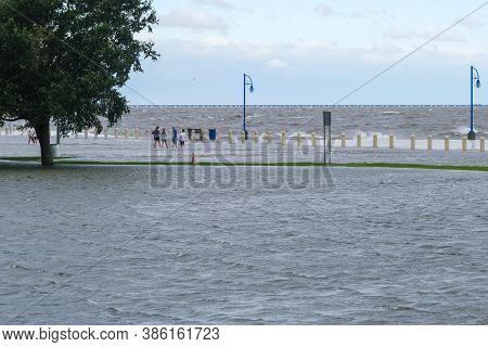 New Orleans, Louisiana/usa - 9/15/2020: Family Wading Along Lake Pontchartrain During Storm Surge Fr