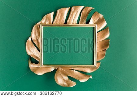 Gold Tropical Palm Leaves Monstera And Photo Frame On Green Background. Flat Lay, Top View Minimal C