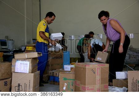 Eunapolis, Bahia / Brazil - April 1, 2008: Correios Employees Sort Orders For Delivery In The City O
