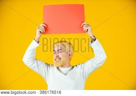 Man Holding A Blank Sheet Of Paper, Isolated On Yellow Background