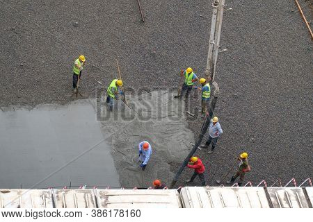 Batumi, Georgia, June 21, 2020: Builder Workers Pouring Concrete On The Ground At Construction Site