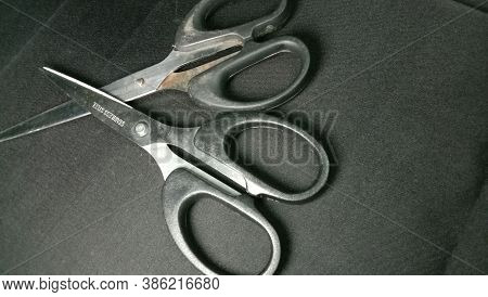Silver And Black Colored Scissors Closeup On Black Background