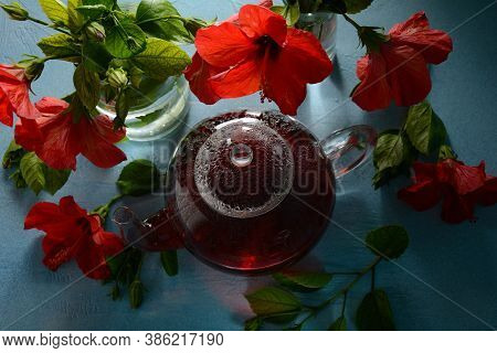 Hibiscus Tea In A Glass Transparent Teapot, And Blossom Flower
