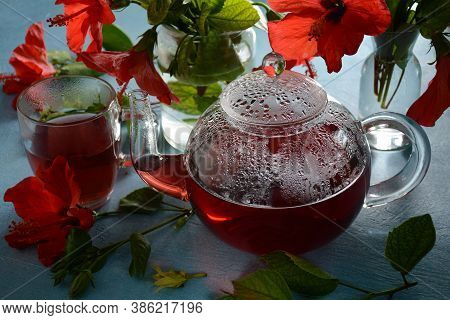Hibiscus Tea In A Glass Transparent Teapot, And Blossom Flower