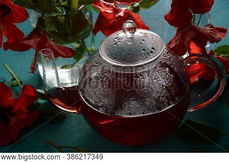 Hibiscus Tea In A Glass Transparent Teapot, And Blossom Flower