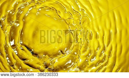 Macro shot of Splashing Oil on Golden Background