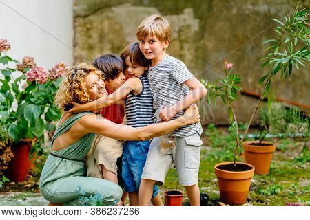 Blond Female Gardener Hugging Her Cute Child Son With