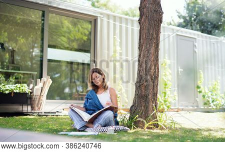 Mature Woman Working In Home Office Outdoors In Garden, Resting.