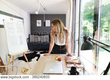 Mature Woman Working Indoors In Home Office In Container House In Backyard.
