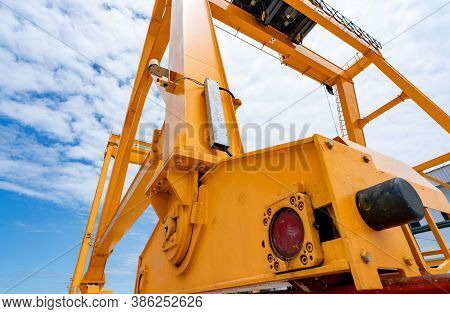 Bottom View Of Yellow Gantry Crane Against Blue Sky At Port. Gantry Crane For Cargo And Construction