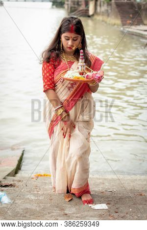 Portrait Of Beautiful Indian Girl Wearing Traditional Indian Saree, Gold Jewellery And Bangles Holdi