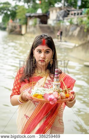 Portrait Of Beautiful Indian Girl Wearing Traditional Indian Saree, Gold Jewellery And Bangles Holdi