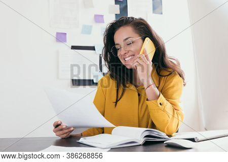 Smiling Pretty Young Businesswoman In Glasses Sitting On Workplace Girl Wearing Yellow Shirt Reading