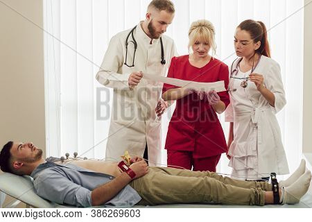 Training With Interns. A Young Blonde Doctor Gives A Lecture To Interns In The Office, Discussing Th