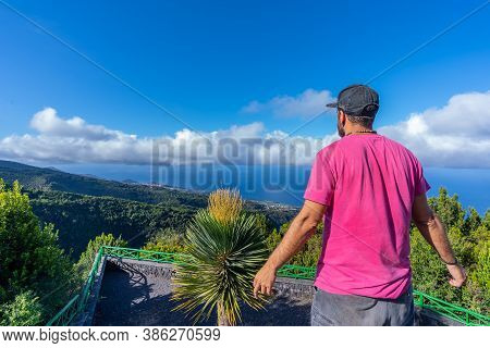 A Young Man In A Pink T-shirt On Top Of The Mountain At The Viewpoint Of The Cubo De La Galga Natura