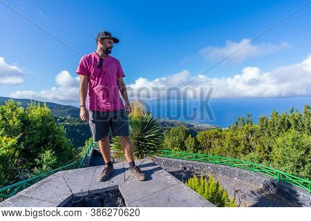 A Young Man In A Pink T-shirt On Top Of The Mountain At The Viewpoint Of The Cubo De La Galga Natura
