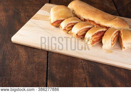 Homemade Bread Stuffed With Ground Mortadella And Tomato Sauce With Black Background. Low Key Image,