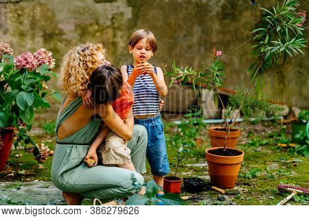 Blond Female Gardener Consolation, Hugging Her Cute Child Son With Down Syndrome, Caressing And Calm