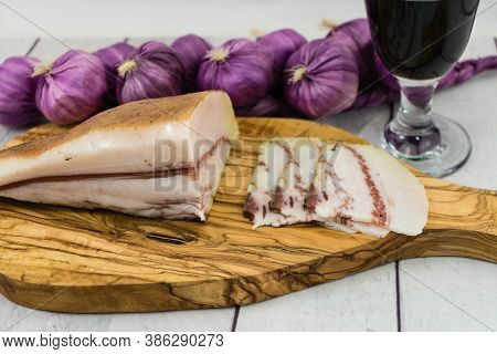 A Piece Of Ham On Olivewood With A Glas Of Redwine