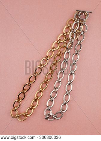 Two Women`s Wrist Chain Bracelets On Pink Shimmering Background