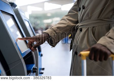 Black Traveler Man Using Self Check-in Machine Kiosk Service At Airport, Finger Point On Display. Cl