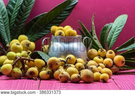 Medlar Fruits In Aluminum Container On Pink Background